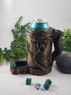 a beer in a mug next to dices and some plants on a white surface