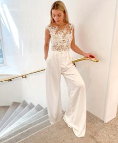 a woman in white is standing on the stairs