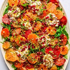 a salad with oranges, feta cheese and pomegranate on top