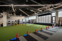 an indoor gym with artificial turf and exercise mats