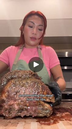 a woman in an apron is preparing a large roast