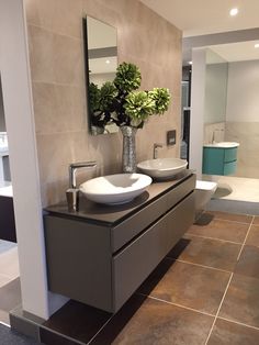 a bathroom with two sinks and mirrors on the wall