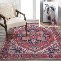 a red rug with blue and white designs on the floor next to a washer