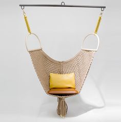 an image of a chair hanging from a rope with a cushion on it and the caption objets nomades swing chair by pattiia utopia for louis vuitton