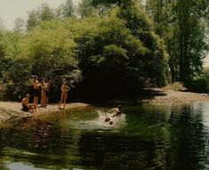 some people are playing in the water and one person is jumping into the water to catch something