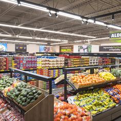 an aisle in a grocery store filled with lots of fresh fruits and veggies