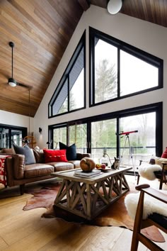 a living room filled with lots of furniture and large windows on top of the ceiling