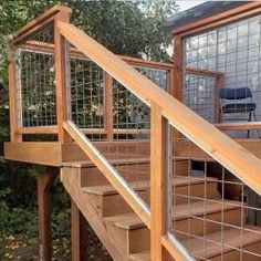 a wooden stair case next to a deck with glass balconies on the side