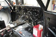 the inside of a car that is being worked on with tools and other items in it