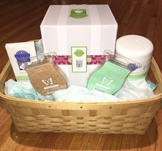 a basket filled with personal care items sitting on top of a wooden floor next to a white box