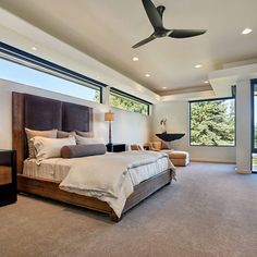 a bedroom with a large bed and ceiling fan