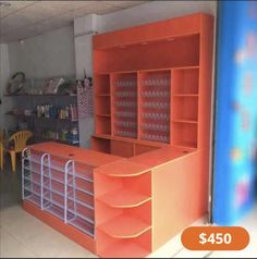 the inside of a store with orange shelves and chairs