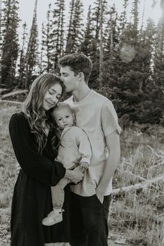 a man and woman holding a baby in their arms