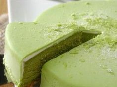 there is a green cake that has been cut in half and ready to be eaten