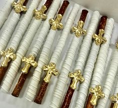 several white candles with gold crosses on them