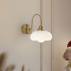 a lamp that is on the wall next to a figurine with a red hat