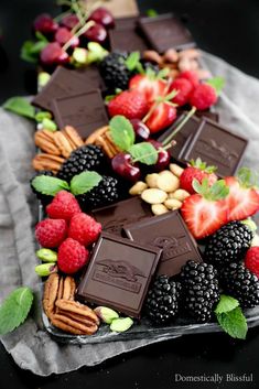 an assortment of chocolates, berries and nuts on a platter