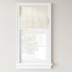 a window with a white roman blind on it