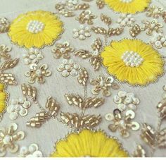 an embroidered fabric with yellow flowers and pearls on white background, text reads peranaqueshibabel