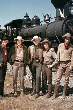 several men standing in front of an old train