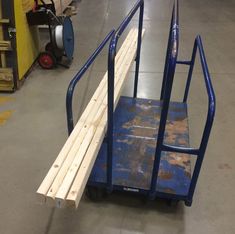 a hand truck with some wooden planks attached to it's back wheels in a warehouse