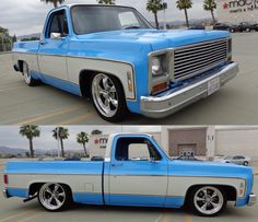 an old blue and white truck parked in a parking lot with palm trees behind it