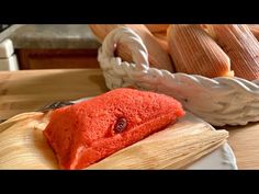 corn on the cob and an orange cake are sitting on a wooden cutting board