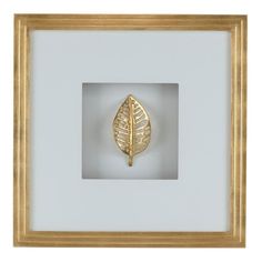 a gold leaf in a white frame