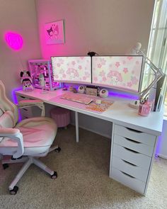 a white desk topped with two computer monitors next to a pink chair and table top