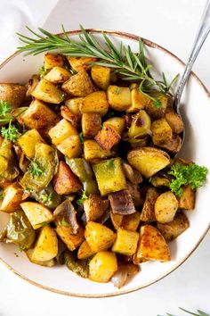 a white bowl filled with potatoes and herbs