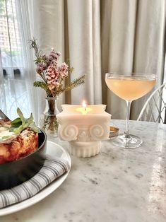 a table topped with plates and glasses filled with food next to a wine glass on top of a counter