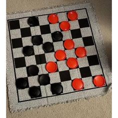 a black and white checker board with red buttons on it's sides, sitting on the floor