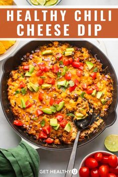 the healthy chili cheese dip in a skillet with tomatoes and avocado