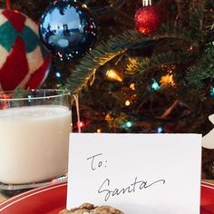 a plate with cookies and milk on it next to a christmas tree