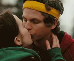 a man and woman kissing each other while wearing headbands