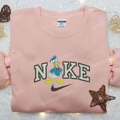 Introducing the Donald Duck x Nike Embroidered Shirt, a unique collaboration that perfectly combines iconic Disney charm with the renowned Nike Embroidered Sweatshirt, Nike Inspiration, Nike Inspired, Embroidered Apparel, Goofy Movie, Disney Shirt, Custom Nikes, Embroidered Clothes, Embroidered Sweatshirt