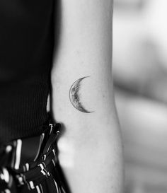 a woman's arm with a half moon tattoo on it