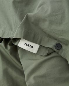 there is a label that says teka on the side of a green jacket with black buttons