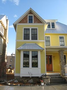 a yellow house with white trim and windows