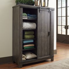 an armoire with towels and blankets in it