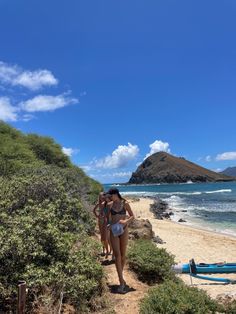 two women walking down a path to the beach