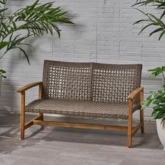 a wooden bench sitting next to two potted plants