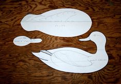 paper cut out of two ducks sitting on top of a wooden table