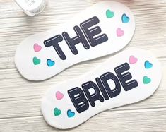 the bride and groom slippers are sitting next to each other on a wooden table