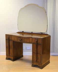 an antique wooden desk with a mirror on top