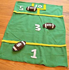 a green table cloth with footballs and numbers on it sitting on a wooden floor