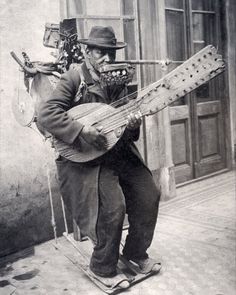 an old black and white photo of a man with a guitar in his hands playing the instrument