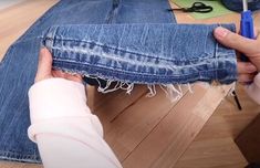 someone is removing the bottom part of a pair of jeans