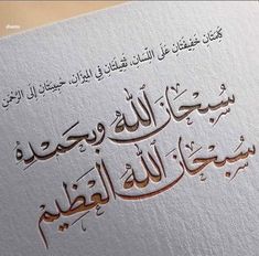 an arabic text on white paper with gold foil and writing in two different languages,