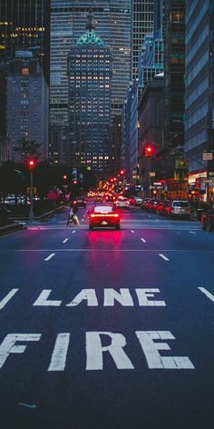 a city street at night with cars driving down it and the words lane fire painted on the road